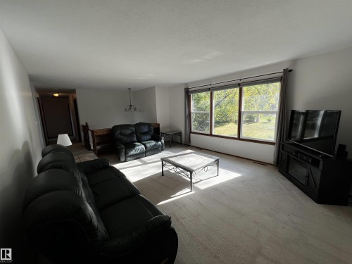 Carpeted living area featuring a textured ceiling - 74038 Birch Avenue, Widewater, AB - Indoor Photo Showing Living Room