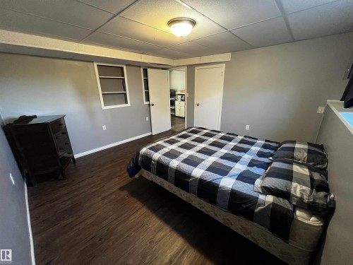 Bedroom with dark wood-style flooring and a drop ceiling - 74038 Birch Avenue, Widewater, AB - Indoor Photo Showing Bedroom