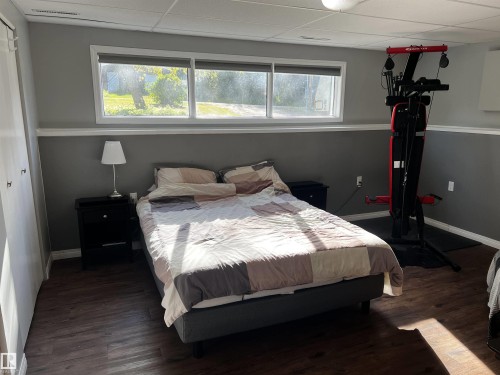 Bedroom featuring dark wood finished floors, a paneled ceiling, and a closet - 74038 Birch Avenue, Widewater, AB - Indoor Photo Showing Bedroom