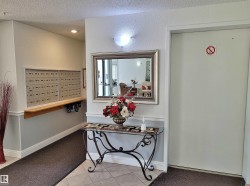 Foyer entrance with a textured ceiling, carpet flooring, mail area, tile patterned floors, and a textured wall - 