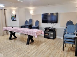 Recreation room with a textured ceiling, crown molding, and light wood-type flooring - 