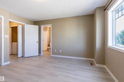 Unfurnished bedroom featuring light wood finished floors, connected bathroom, a textured ceiling, and washer / dryer - 