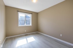 Empty room with light wood-type flooring and a textured ceiling - 