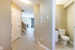 Hall with a textured ceiling, light wood finished floors, and stairway - 