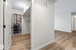 Spacious closet featuring light wood-style flooring, washer / clothes dryer, and gas water heater - 