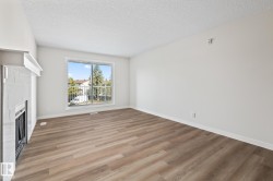 Unfurnished living room with light wood-style floors, a textured ceiling, and a fireplace - 