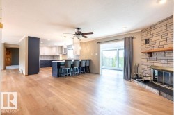 Kitchen featuring a kitchen breakfast bar, ornamental molding, white cabinetry, light wood finished floors, and a peninsula - 