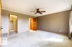 Unfurnished bedroom with ornamental molding, a ceiling fan, and carpet - 