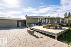 Back of property featuring a deck and a patio area - 