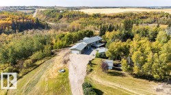 Aerial view of property and surrounding area featuring a heavily wooded area - 