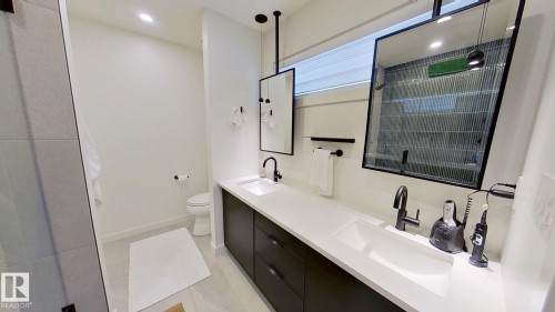 Bathroom featuring double vanity, a shower stall, and light tile patterned floors - 11308 128 Street, Edmonton, AB - Indoor Photo Showing Bathroom