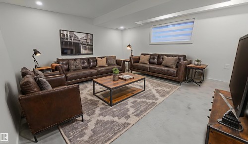 Living area with finished concrete floors and recessed lighting - 11308 128 Street, Edmonton, AB - Indoor