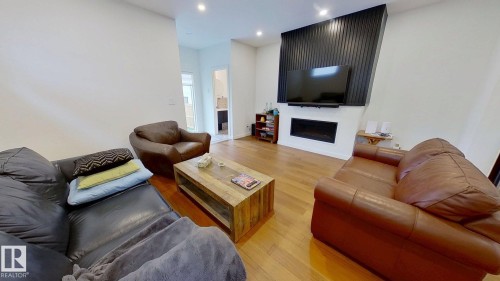 Living area with light wood-style flooring, a fireplace, and recessed lighting - 11308 128 Street, Edmonton, AB - Indoor Photo Showing Living Room