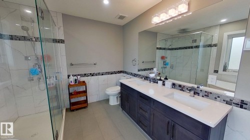 Full bathroom featuring tile walls, a stall shower, and double vanity - 8809 148 Street, Edmonton, AB - Indoor Photo Showing Bathroom