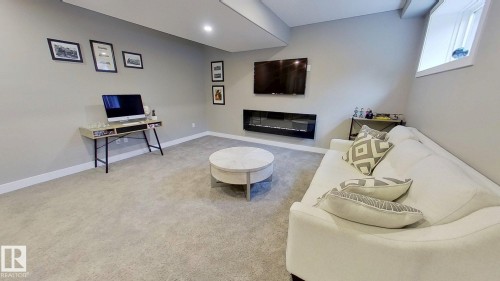 Living area with light colored carpet and baseboards - 8809 148 Street, Edmonton, AB - Indoor With Fireplace