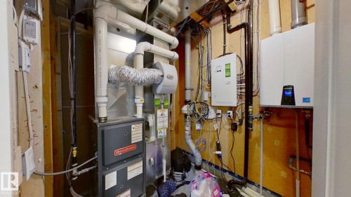Utility room featuring tankless water heater and heating unit - 8809 148 Street, Edmonton, AB - Indoor Photo Showing Basement