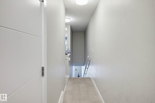 Hallway featuring light tile patterned floors and a textured ceiling - 90 2560 Pegasus Boulevard, Edmonton, AB - Indoor Photo Showing Other Room