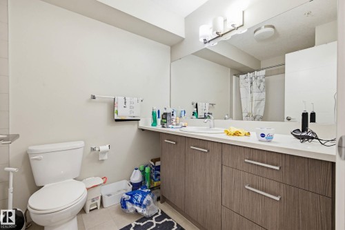 Full bath with vanity, a shower with shower curtain, and light tile patterned floors - 90 2560 Pegasus Boulevard, Edmonton, AB - Indoor Photo Showing Bathroom