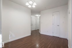 Empty room featuring dark wood finished floors and a chandelier - 