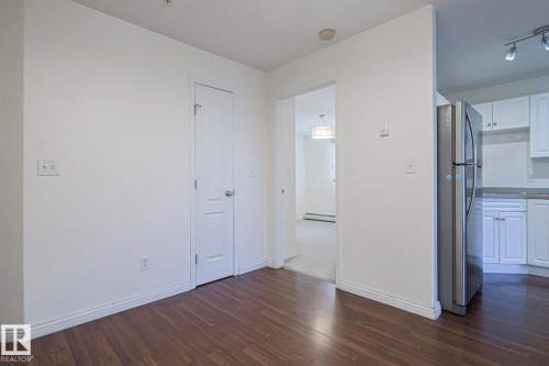 Spare room featuring dark wood-style flooring and a baseboard heating unit - 120 7511 171 Street Nw, Edmonton, AB - Indoor Photo Showing Other Room