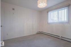 Unfurnished room with a baseboard heating unit, carpet floors, and a chandelier - 