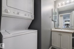 Laundry area featuring stacked washer and clothes dryer and baseboards - 