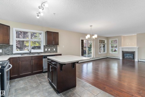 132 11603 Ellerslie Road, Edmonton, AB - Indoor Photo Showing Kitchen With Fireplace