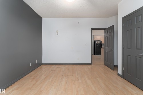 Spare room with light wood-type flooring and a textured ceiling - 101 6220 134 Avenue, Edmonton, AB - Indoor Photo Showing Other Room