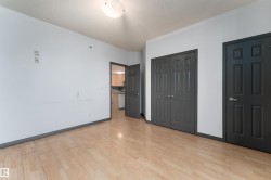 Unfurnished bedroom with multiple closets, light wood finished floors, and a textured ceiling - 