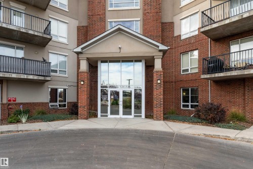 Property entrance with french doors, brick siding, and stucco siding - 101 6220 134 Avenue, Edmonton, AB - Outdoor With Balcony