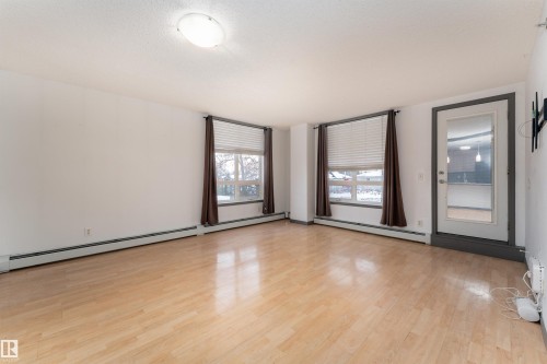 Unfurnished room with baseboard heating and light wood finished floors - 101 6220 134 Avenue, Edmonton, AB - Indoor Photo Showing Other Room