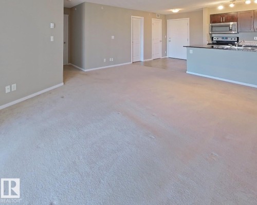 Unfurnished living room featuring baseboards - 404 5370 Chappelle Road, Edmonton, AB - Indoor Photo Showing Kitchen