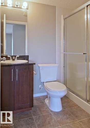 Bathroom featuring a shower stall, vanity, and a textured ceiling - 404 5370 Chappelle Road, Edmonton, AB - Indoor Photo Showing Bathroom