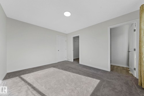 Unfurnished bedroom with a walk in closet and carpet flooring - 1813 Collip View View, Edmonton, AB - Indoor Photo Showing Other Room