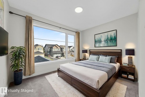 Carpeted bedroom with baseboards and a residential view - 1813 Collip View View, Edmonton, AB - Indoor Photo Showing Bedroom