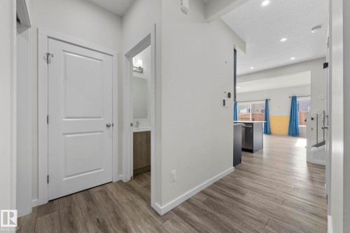 Hall with light wood-type flooring, recessed lighting, and a textured ceiling - 1813 Collip View View, Edmonton, AB - Indoor Photo Showing Other Room
