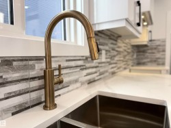 Kitchen view of decorative backsplash and light stone counters - 