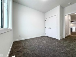 Unfurnished bedroom featuring dark carpet, a textured ceiling, and a closet - 
