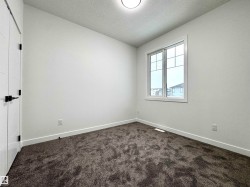 Unfurnished room with a textured ceiling and dark carpet - 