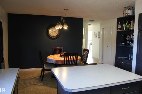 Dining space featuring dark tile patterned flooring and a chandelier - 5221 54A Street, Elk Point, AB - Indoor Photo Showing Dining Room