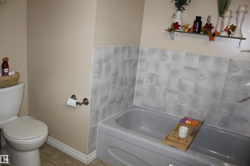 Bathroom with a bath and tile patterned flooring - 5221 54A Street, Elk Point, AB - Indoor Photo Showing Bathroom