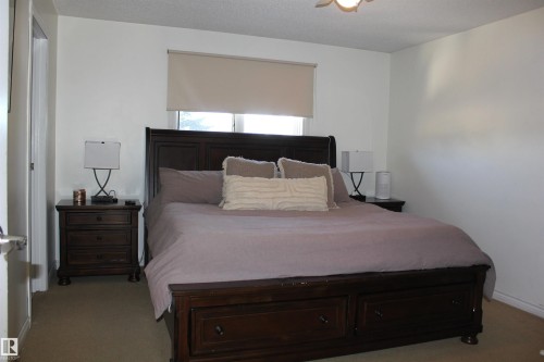 Bedroom with light carpet, a textured ceiling, and a ceiling fan - 5221 54A Street, Elk Point, AB - Indoor Photo Showing Bedroom