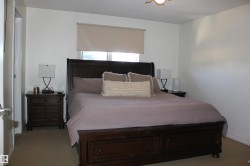 Bedroom with light carpet, a textured ceiling, and a ceiling fan - 