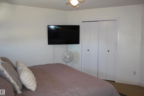 Bedroom with carpet, a textured ceiling, a closet, and ceiling fan - 5221 54A Street, Elk Point, AB - Indoor Photo Showing Bedroom