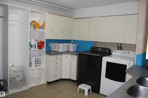 Laundry area featuring cabinet space and washing machine and dryer - 5221 54A Street, Elk Point, AB - Indoor Photo Showing Laundry Room