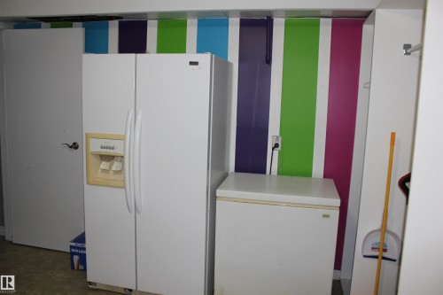 Kitchen with white refrigerator with ice dispenser and light countertops - 5221 54A Street, Elk Point, AB - Indoor Photo Showing Other Room
