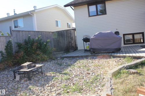 Fenced backyard featuring a fire pit and a deck - 5221 54A Street, Elk Point, AB - Outdoor With Exterior