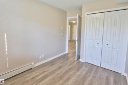 Unfurnished bedroom featuring baseboard heating, light wood finished floors, a closet, and a textured ceiling - 