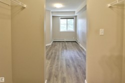Walk in closet featuring light wood-type flooring and a baseboard radiator - 