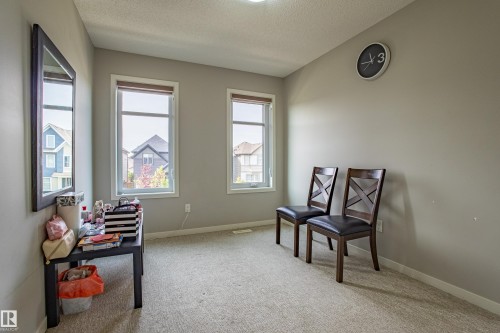 Living area with light carpet and a textured ceiling - 2407 Casey Link, Edmonton, AB - Indoor Photo Showing Other Room